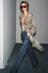 Pantalón de tiro alto confeccionado en algodón, con corte recto y diseño minimalista. Presenta bolsillos laterales, raya planchada en el delantero y cierre frontal con cremallera, botón y ganchos metálicos.