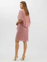 Vestido midi de tejido metalizado color turquesa, con sobrecapa de tul liviano sobre los hombros, detalle de pedrería en la cintura, volado lateral y tajo frontal.