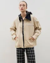 Campera de jean azul oscuro con cuello de pana en color crema. Presenta cierre frontal metálico, bolsillo con cierre en el pecho y bolsillos laterales. Diseño de corte holgado con mangas largas.