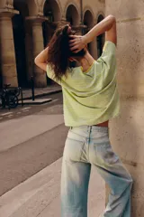 Camiseta de corte regular fit, cuello redondo y manga corta, confeccionada en una mezcla de algodón y lino. Presenta un diseño a rayas horizontales en tonos verdes y amarillos, con paneles laterales y mangas que combinan rayas verticales.