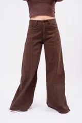 Jean wide-leg color marrón chocolate, con tiro medio, bolsillos frontales y traseros, y costuras decorativas verticales a lo largo de las piernas.