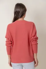 Cárdigan negro de punto con escote en V y cierre frontal con botones marrones.