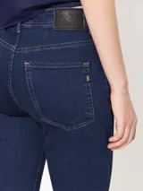 Jeans azul oscuro con corte cropped, tiro medio y pinzas diagonales en la parte delantera.