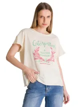 Remera de corte relajado color beige, con cuello redondo y mangas cortas. Presenta un estampado gráfico frontal con motivos botánicos y tipografía retro en tonos verde y rosado.