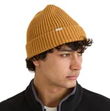 Gorro tipo beanie de punto acanalado color amarillo mostaza, con doblez en el borde y pequeña etiqueta de marca Rhythm.