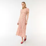 Vestido midi de color blanco con estampado floral rojo, escote en V con botones frontales, mangas cortas y corte entallado en la cintura.