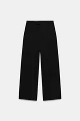 Pantalón de corte ancho y tiro bajo, con trabillas en la cintura, bolsillos laterales y falsos bolsillos traseros. Cuenta con cierre frontal de cremallera, botón interior y gancho metálico.