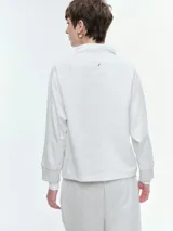 Buzo de cuello polo con escote abotonado, manga larga raglán y puños acanalados. Confeccionado en tejido suave y confortable.