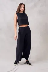 Pantalón negro de corte ancho, tiro alto y textura suave.