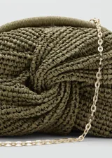 Bolso tipo clutch color verde militar, confeccionado en tejido de fibra natural con diseño trenzado frontal y detalle de nudo. Cuenta con cierre de aro a presión y forro interior.
