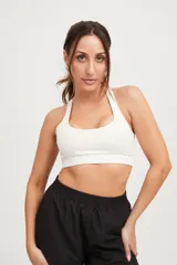 Top deportivo blanco con tiras cruzadas en la espalda y elástico en la cintura.