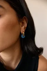 Aros dorados con dije circular de piedra natural negra.
