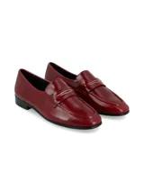 Mocasines de cuero color bordó, con detalle de antifaz en el empeine y suela plana con pequeño tacón.