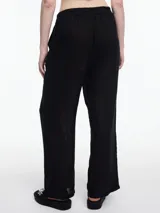 Pantalón de lino 100% color negro, con cintura elástica y calce relajado. Incluye bolsillos laterales y un bolsillo invertido. Los detalles de bordado tipo pespunte en color contraste recorren la pier pierna y el bajo.