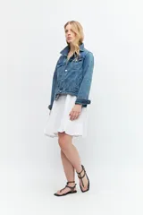 Vestido corto blanco de lino con breteles finos, corte recto y volado en el ruedo.