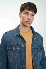 Campera de jean unisex con calce clásico, diseño de lavado claro, cierre frontal con botones metálicos y bolsillos con solapa en el pecho.