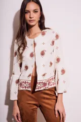 Blusa blanca con bordado de cachemir en negro, corte oversize y mangas acampanadas.