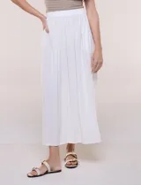 Falda larga de color blanco con pretina elastizada y fruncidos en la cintura, con caída holgada y ligera.