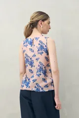 Top sin mangas de silueta recta y caída liviana, color rosado con estampado floral abstracto en azul. Presenta escote redondo.