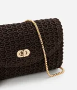 Cartera pequeña de rafia color marrón oscuro con textura de efecto paja. Posee una correa de cadena dorada para uso transversal y un cierre frontal de metal tipo locker.