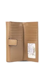 Billetera larga de símil cuero color marrón claro, con solapa frontal decorada con un aro metálico central. Cuenta con múltiples compartimentos internos para tarjetas, billetes y un monedero con cierre.