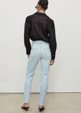 Jeans mom-fit de tiro alto en color celeste claro, con diseño de cinco bolsillos, trabillas para cinturón y cierre frontal con cremallera y botón.