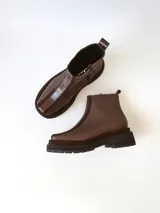 Bota corta de cuero en tonos chocolate, con diseño de paneles texturizados y suela track robusta de goma.