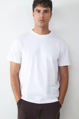 Camiseta básica de manga corta con corte relaxed, confeccionada en algodón. Diseño minimalista de cuello redondo, ideal para uso diario.