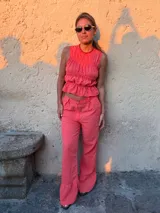 Pantalón largo de tiro alto con estampado a cuadros vichy en tonos rojo y blanco, de corte recto y holgado.