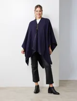 Ruana negra de tejido suave, con cierre frontal de botones metálicos y ribetes de cuero sintético en los bordes.