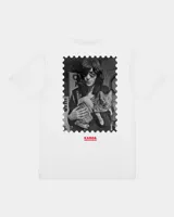 Remera de manga corta blanca con diseño gráfico en la espalda estilo estampilla que muestra una fotografía en blanco y negro de una persona con un gato, acompañada del logotipo rojo de Kaboa Industries.