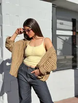Camisa escocesa holgada, de manga larga, con estampa de cuadros en tonos de verde y marrón, y cierre frontal con botones.