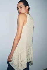 Vestido corto de viscosa color beige con diseño de jacquard, escote redondo y manga sisa. Presenta un diseño de paneles asimétricos con aplicaciones de abalorios decorativos en las costuras.