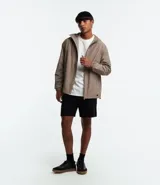 Campera rompevientos color verde oliva con capucha ajustable con cordón, cierre frontal con cremallera, bolsillos laterales con cremallera, puños con elástico y forro interior. Ligera y versátil, ideal para proteger del viento y la lluvia ligera.