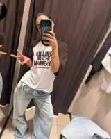 Remera estilo raglan con cuerpo blanco y mangas cortas marrones, con diseño gráfico inspirado en Rage Against The Machine y la frase 'Killing In The Name Of' en el frente.