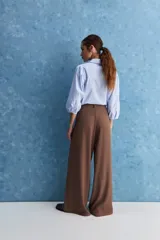 Pantalón wide leg de color negro, con cintura de tiro alto, lazo ajustable y caída fluida.