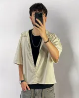 Camisa beige de corte boxy fit, manga corta y confeccionada en lino viscosa.