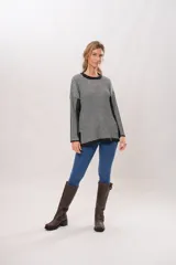 Sweater de punto con cuello redondo y mangas largas. Diseño a rayas verticales en tonos gris y negro.
