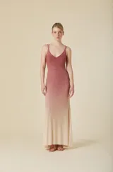 Vestido largo de tul color verde agua, con escote en V, tirantes dobles finos y detalles de pedrería brillante distribuida por toda la prenda. Presenta una silueta ajustada en el torso que se abre suavemente hacia el ruedo.