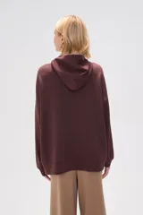 Canguro negro holgado con capucha y cordones ajustables, mangas largas y bolsillos laterales.