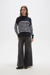 Polera de punto con diseño a rayas horizontales en contraste, cuello alto y mangas largas con puños ajustados.