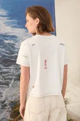 Remera blanca de algodón con bordados coloridos inspirados en la playa, de corte recto y manga corta.