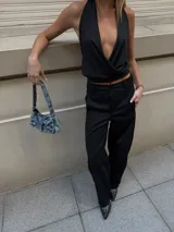 Top negro con escote halter pronunciado y diseño cruzado en el delantero.