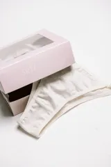 Pack de tres bombachas tipo vedetina de algodón, con tiras laterales regulables. El set incluye una unidad en color negro, una en gris melange y una en blanco.