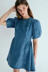 Vestido corto de denim de algodón con cuerpo entallado, cuello redondo, mangas cortas abullonadas y pollera acampanada con paneles y frunces.
