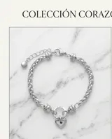 Pulsera de eslabones de acero con dije central en forma de corazón y cierre circular.