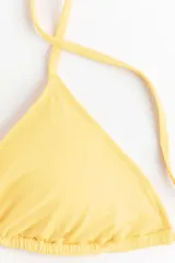 Top de bikini forrado de color amarillo, con copas triangulares y relleno extraíble, tiras ajustables para atar en el cuello y la espalda.