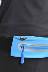 Riñonera deportiva negra con dos bolsillos con cierre y detalles reflectantes.