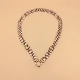 Gargantilla de eslabones plateados con detalles en oro y cierre de aro con barrita.