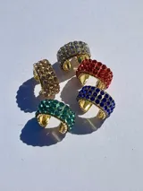 Earcuff dorado con incrustaciones de strass en varios colores.